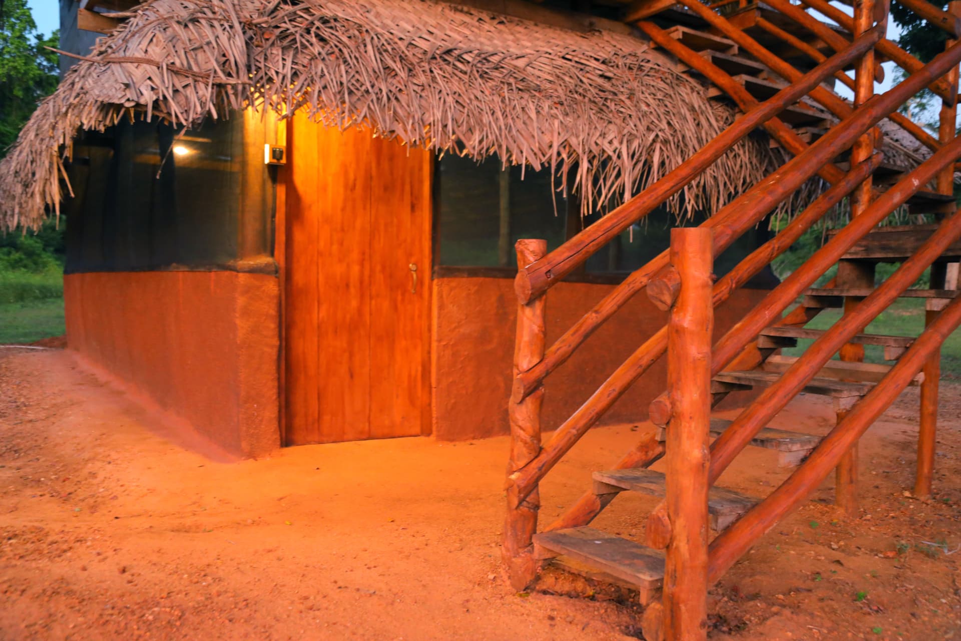 Handcrafted wooden staircase leading to the upper deck of the Nature Win Yala villa — the craftsmanship of traditional Sri Lankan design.